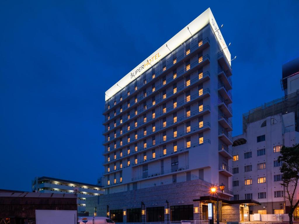 a tall building with lights on in a city at Super Hotel Beppu Ekimae in Beppu