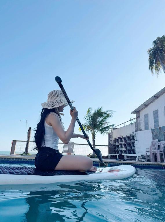 a woman sitting on a paddle board in the water at MUINE MOMO Homestay in Ấp Khánh Phước (1)