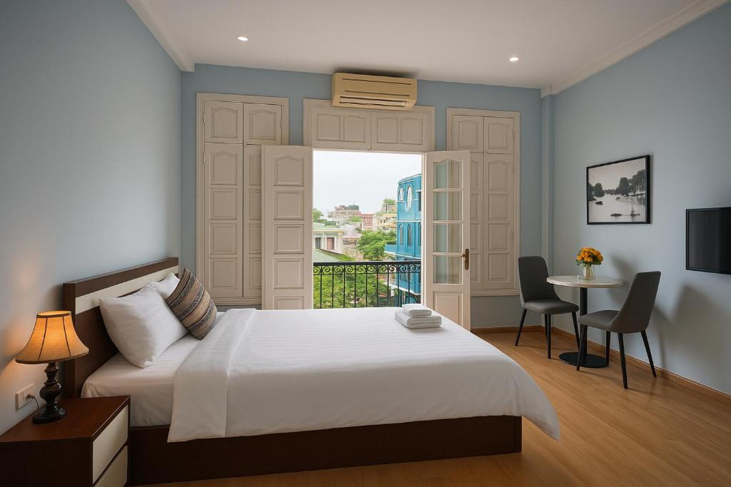 a bedroom with a large bed and a balcony at Eco Nest Hotel 6 Đình Ngang in Hanoi