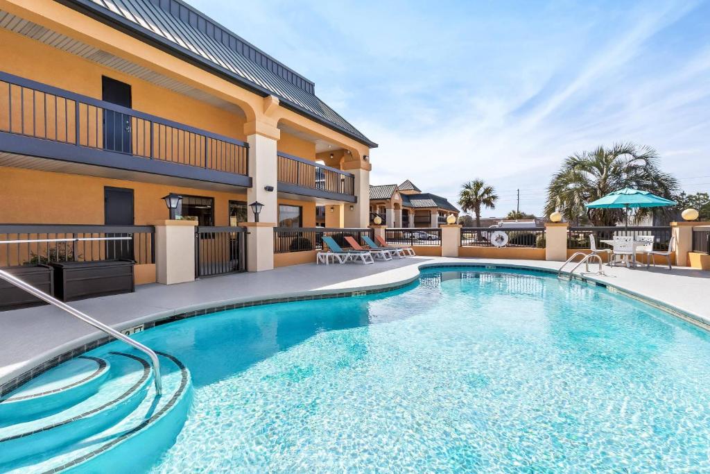 a pool at a hotel with chairs and a building at Quality Inn & Suites Florence Civic Center in Florence