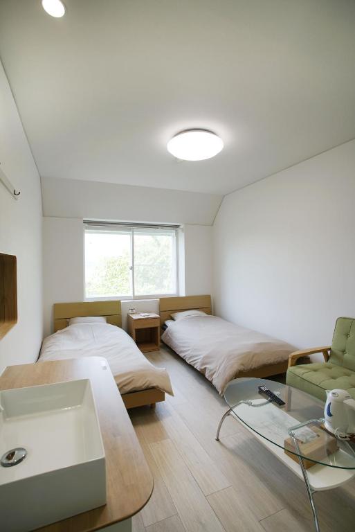a bedroom with two beds and a glass table at レインボーマリン in Mihama
