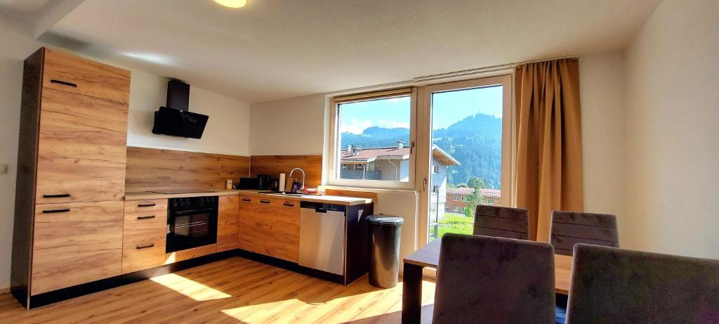 a kitchen with a table and a large window at Ferienwohnung Sonnenschein in Balderschwang