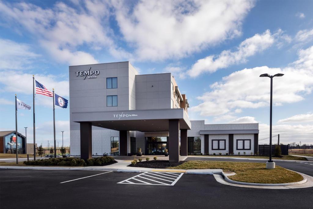 a view of a hotel with an american flag at Tempo By Hilton Manassas in Manassas