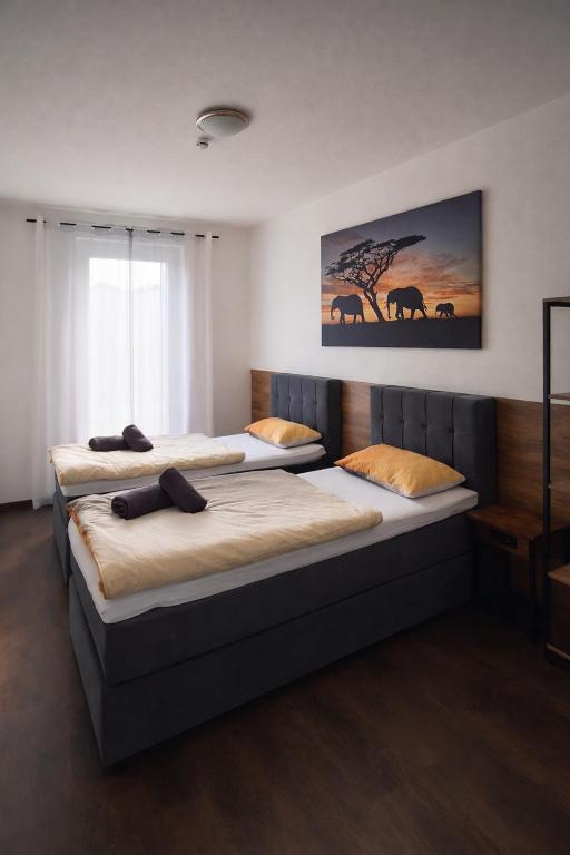 a bedroom with two beds and a painting on the wall at ApartDays Sarstedt in Sarstedt