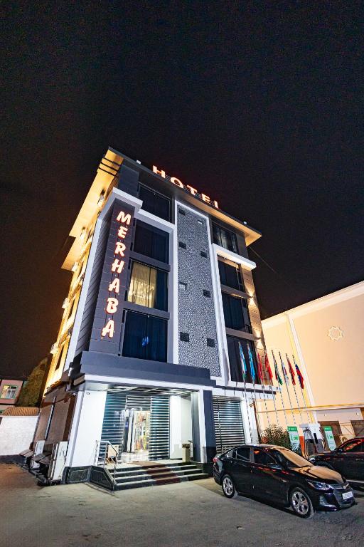 a building with a car parked in front of it at Merhaba Hotel, Fergana in Fergana