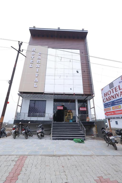 a hotel building with motorcycles parked in front of it at Hotel Carnival in Bāghpat