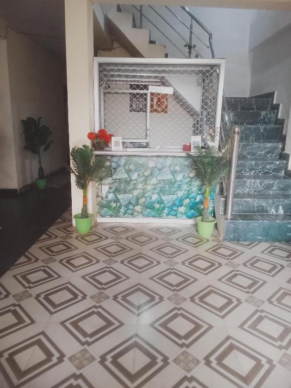 a room with a tile floor and stairs with plants at Hotel Suryawanshi in Nalmatha