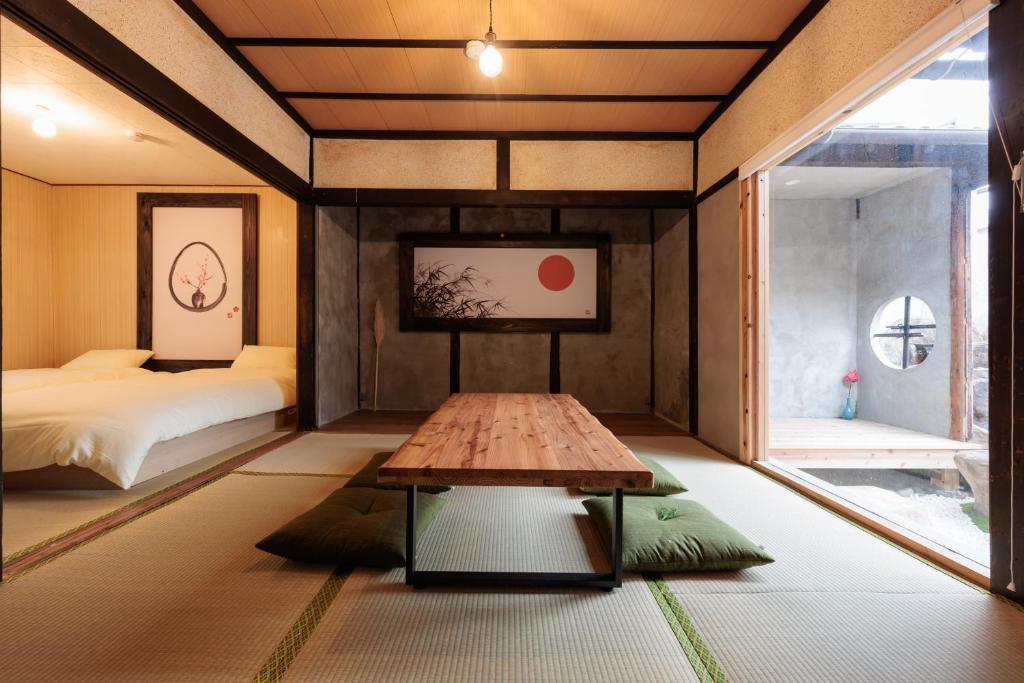 a room with a table and a bed and a window at 穂庵-Hoan- in Tanabe