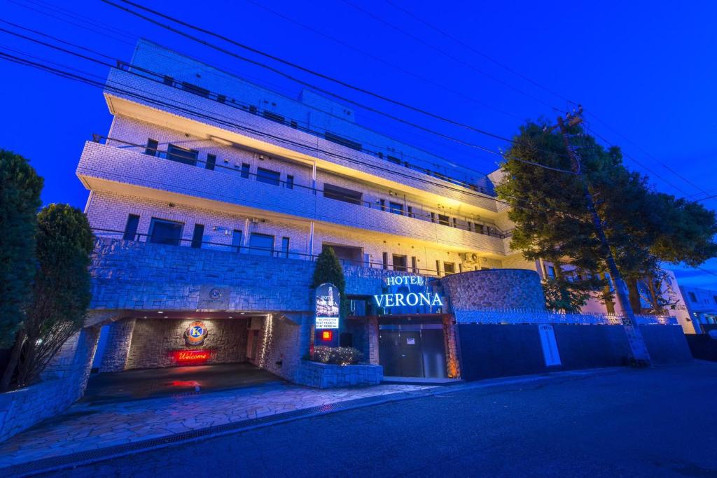 a building with a sign that reads spotatown at night at ホテルヴェローナ in Yokohama
