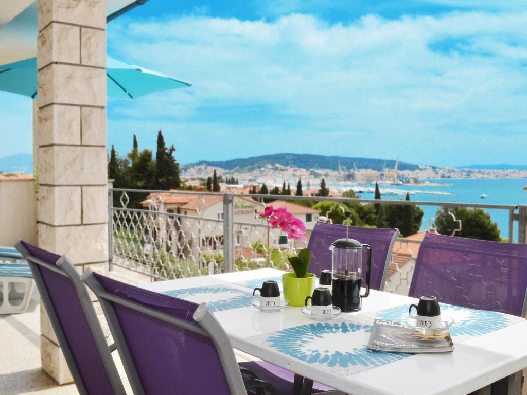 a table with purple chairs and a view of the ocean at Apartment T&M in Trogir