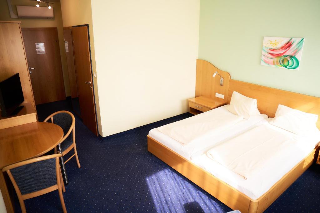 a small room with a bed and a table at Gasthof Hotel Lang in Rauchwart im Burgenland