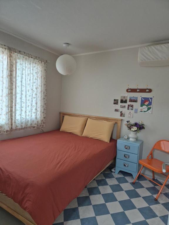 a bedroom with a red bed and a chair at 어게인수영 in Suyŏng