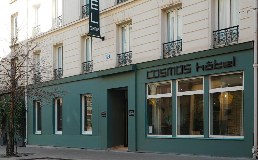 a store front of a building with a green facade at Hotel Cosmos in Paris