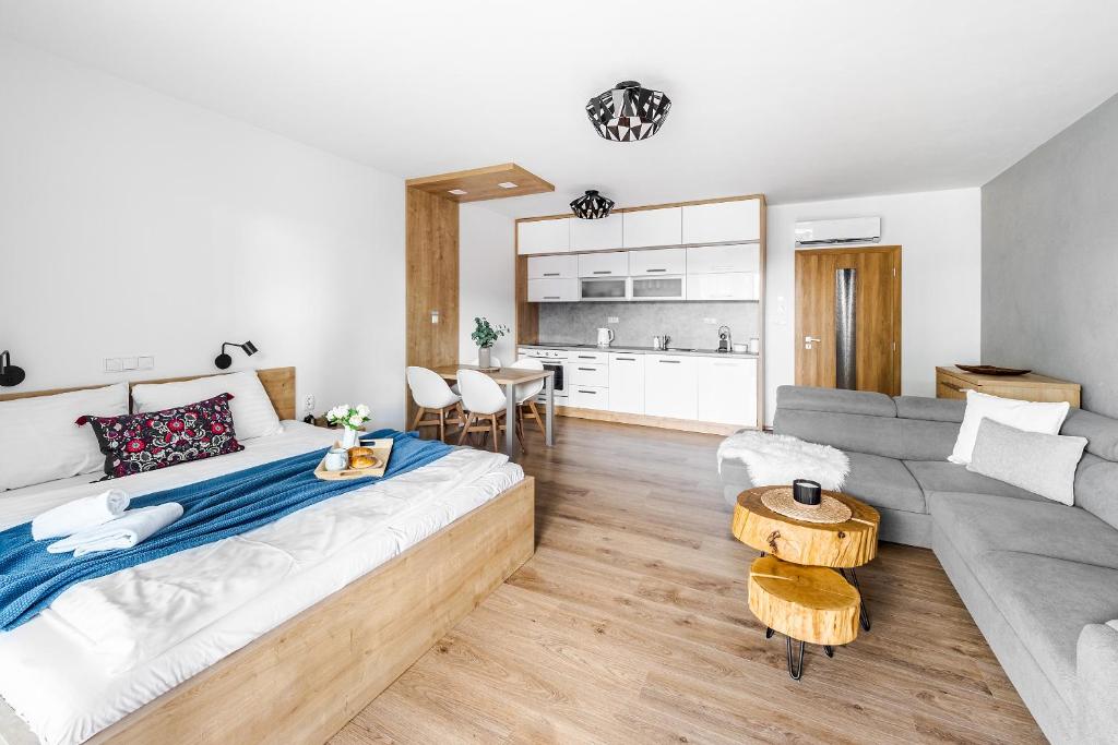 a living room with a large bed and a couch at Jen tak Lipno in Lipno nad Vltavou