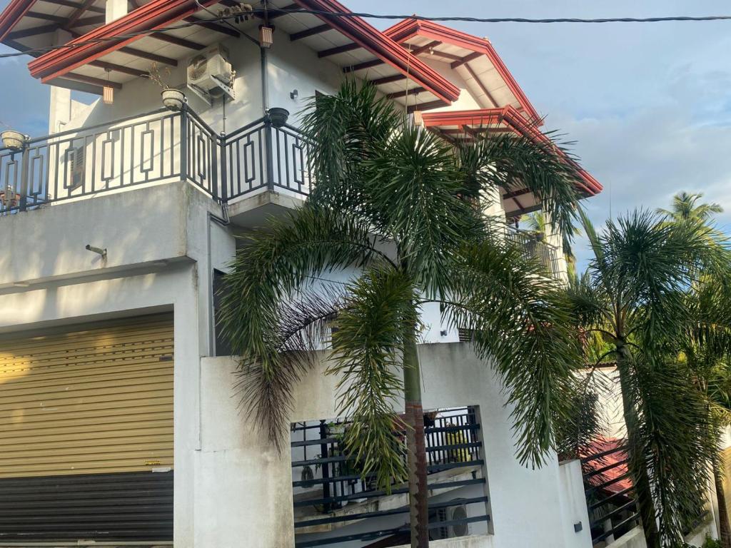 a building with a balcony and a palm tree at Southern Surf Villa in Dickwella