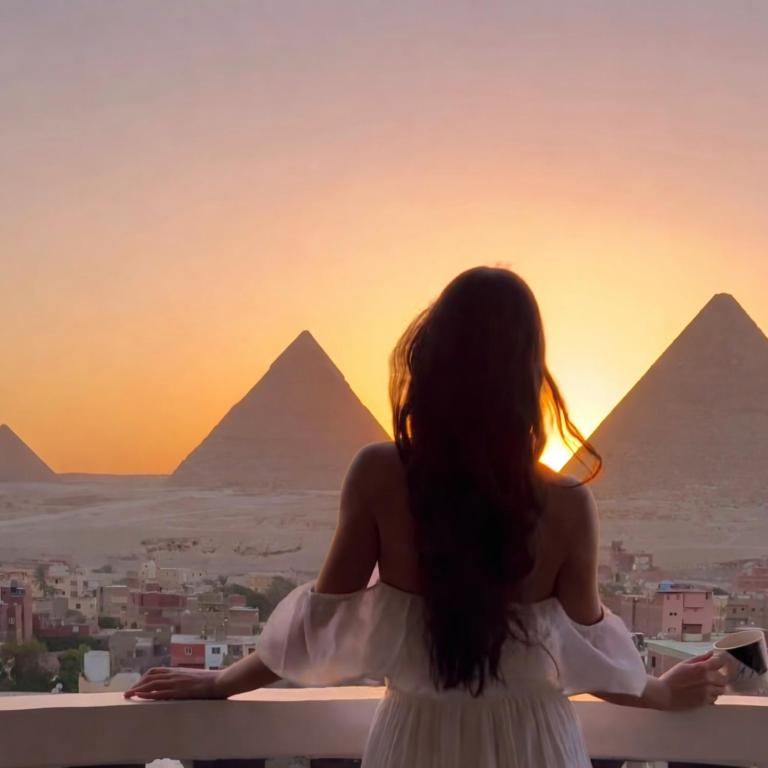 Eine Frau betrachtet die Pyramiden bei Sonnenuntergang in der Unterkunft Pyramids Suite in Kairo