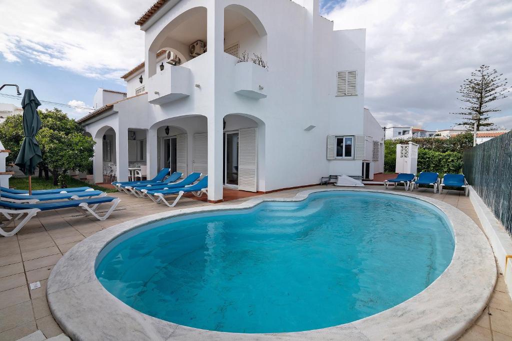 a swimming pool in front of a house at Villa Martins in Albufeira
