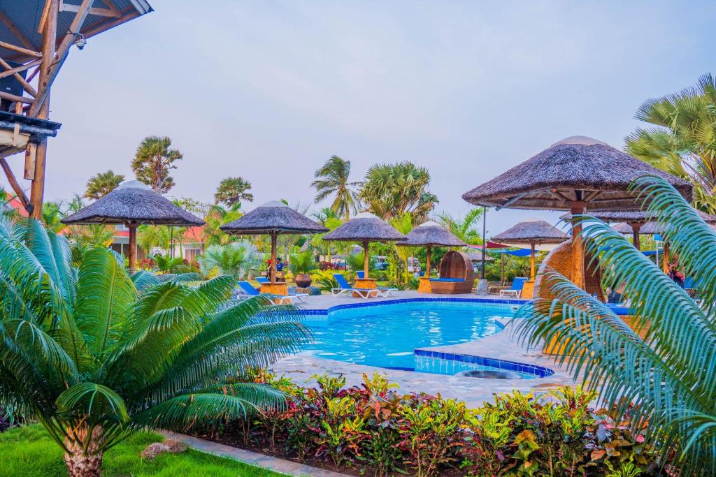 a pool at a resort with umbrellas and plants at Sea Eagle Oceanfront in Buyuni