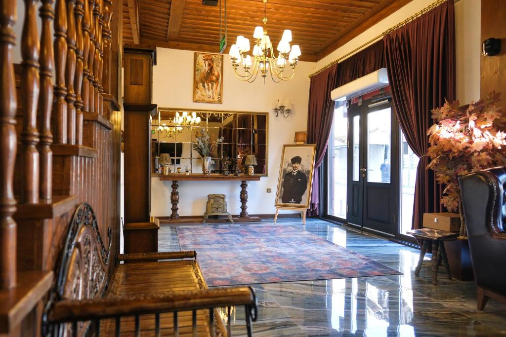a living room with a chandelier and a table and chairs at Gülce Köşk Otel & Restaurant in Amasya