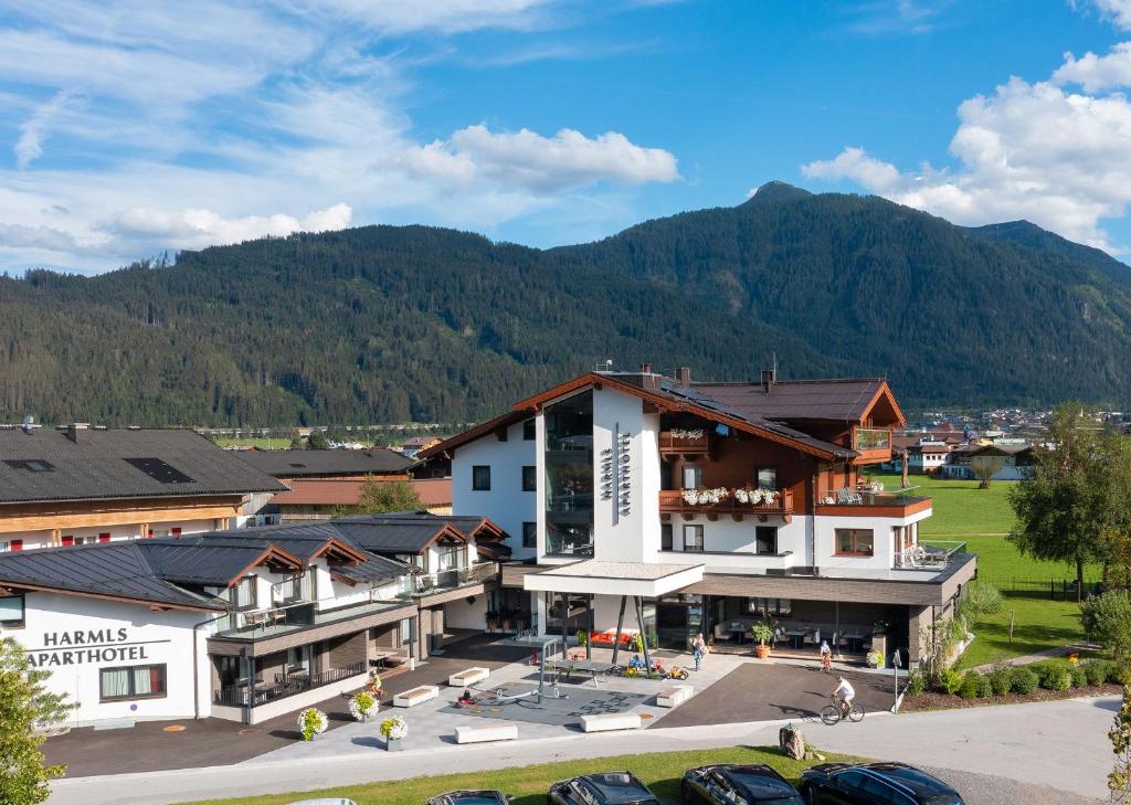 an image of a hotel with mountains in the background at Harmls Aparthotel in Flachau