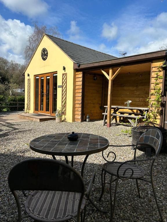 a table and chairs in front of a cabin at Mini haven in Oswestry