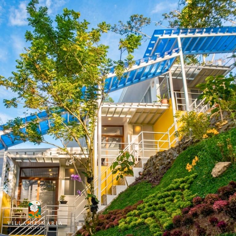 a house on a hill with stairs and flowers at Villa de Maria Suites in Binungan