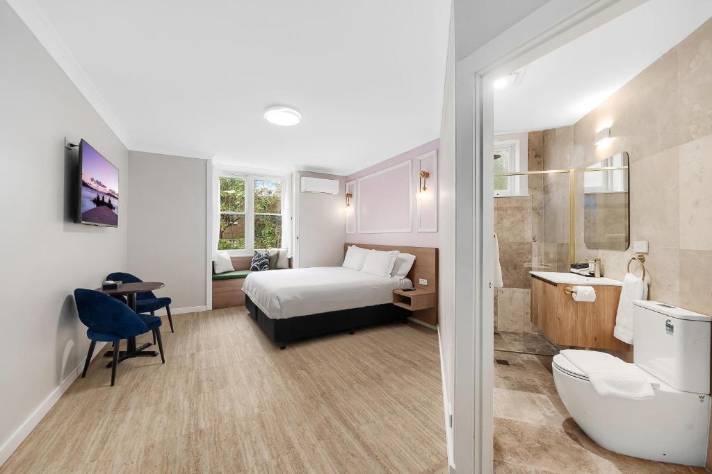 a hotel room with a bed and a bathroom at Hotel Avonleigh in Katoomba