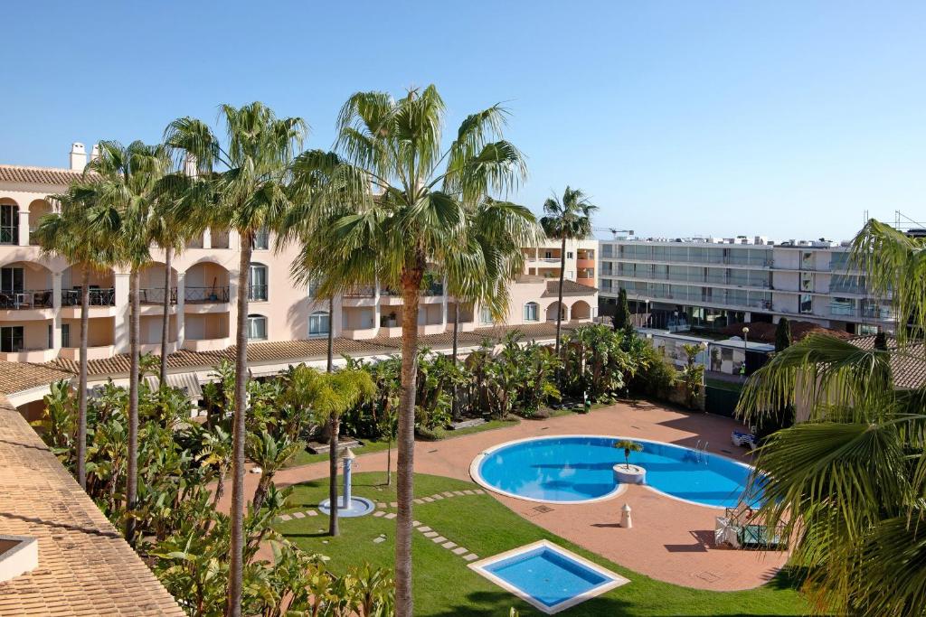 an aerial view of a resort with a pool and palm trees at Vilamoura Golfe Mar in Quarteira