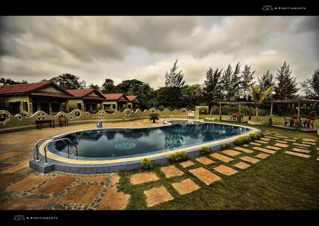 a large swimming pool in the yard of a house at Breathing Earth - Rooms and Pool in Kolkata