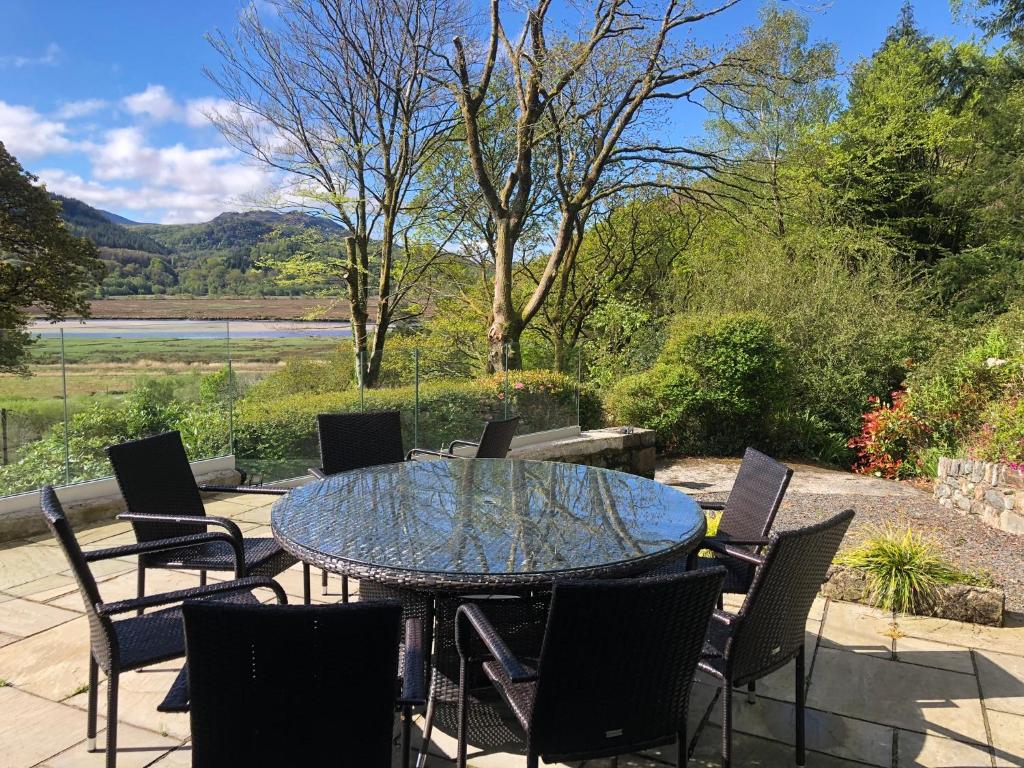 a glass table and chairs on a patio at Snowdonia Mawddach escape in Dolgellau