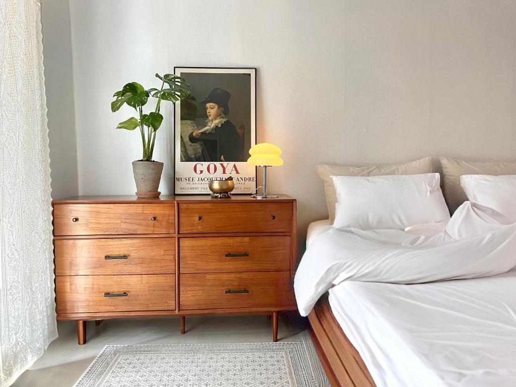 a bedroom with a bed and a dresser with a book at Gold Stream House in Seoul