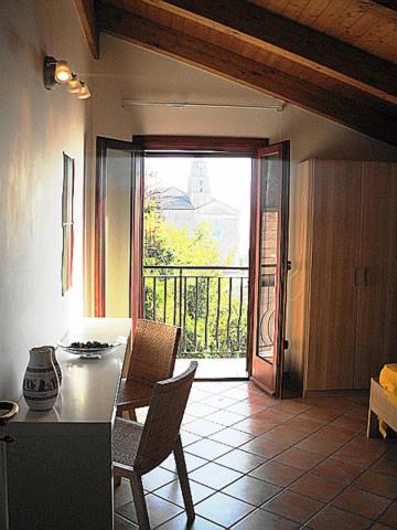 a kitchen with a table and chairs and a balcony at Gelsomino home in Furore
