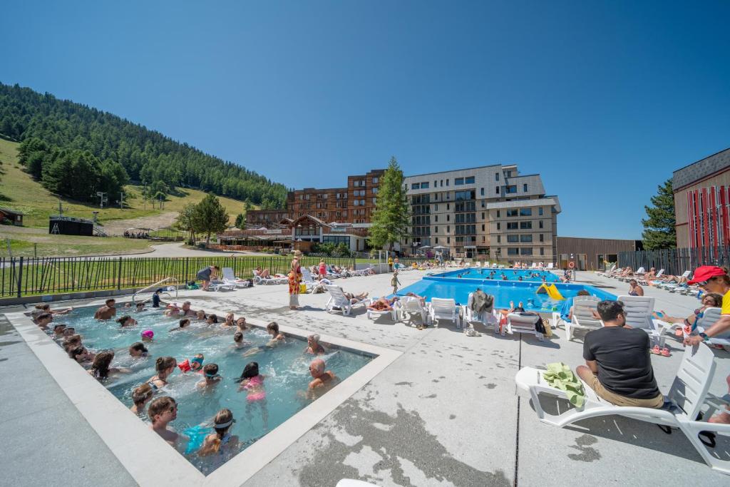 a group of people sitting in a swimming pool at Résidence Kocoon Les Karellis - Pass activités été inclus in Montricher-Albanne