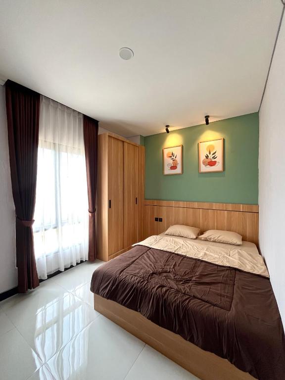 a bedroom with a bed and a green wall at Pangeran Residence 2 in Adi Sutjipto