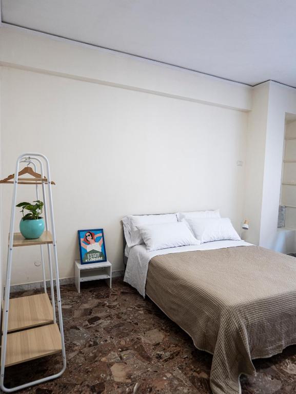 a white bedroom with a bed and a ladder at Casa e Puteca in Torre del Greco
