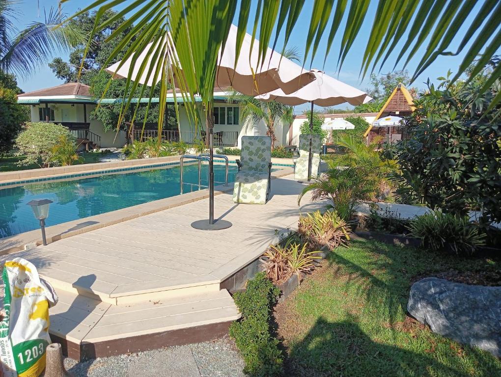a swimming pool with a chair and an umbrella at TRANQUILITY Resort in Nong Prue