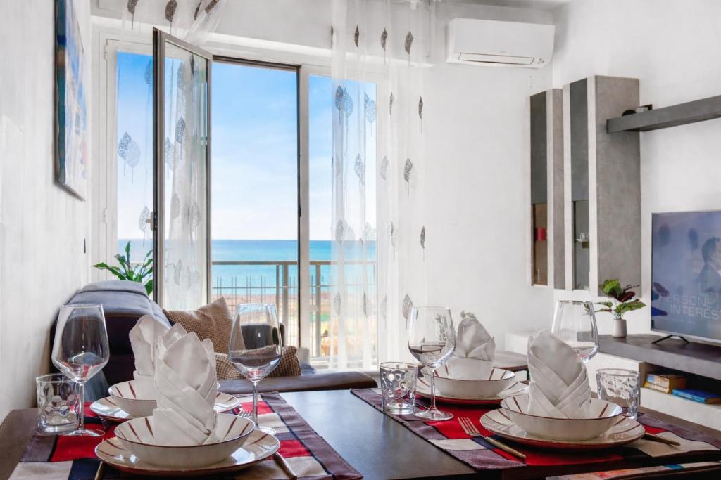 a dining room with a table with a view of the ocean at Victoria Seafront - Sea View Private Parking AC & WiFi in Savona