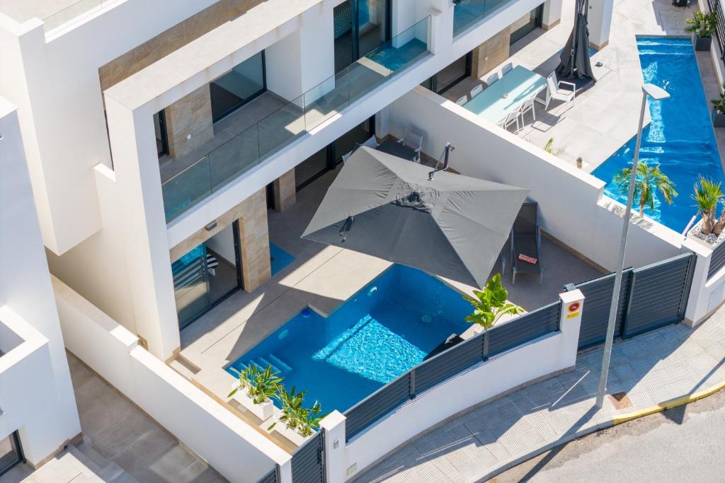 an overhead view of a building with a swimming pool and an umbrella at R-40-B Luxury Villa with pool in Los Montesinos
