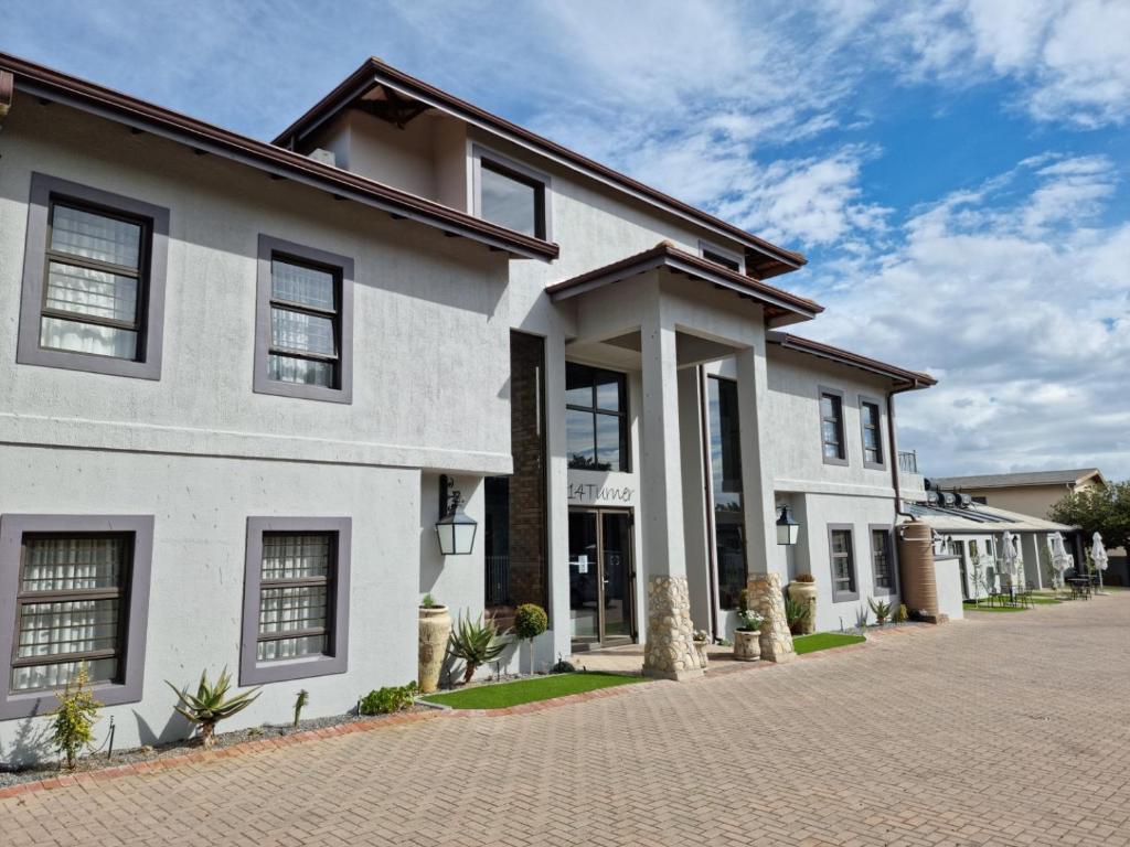 a white house with a brick driveway at Balmoral Lodge in Bellville