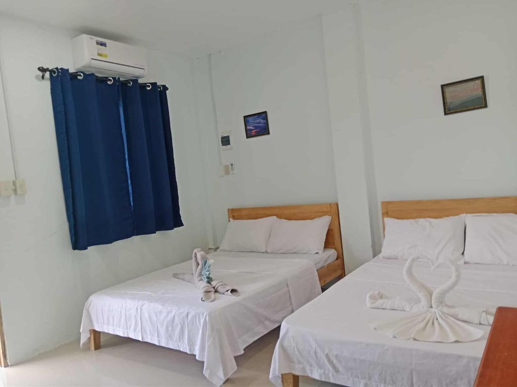 a room with two beds and a blue curtain at The Soul Center in Batuan
