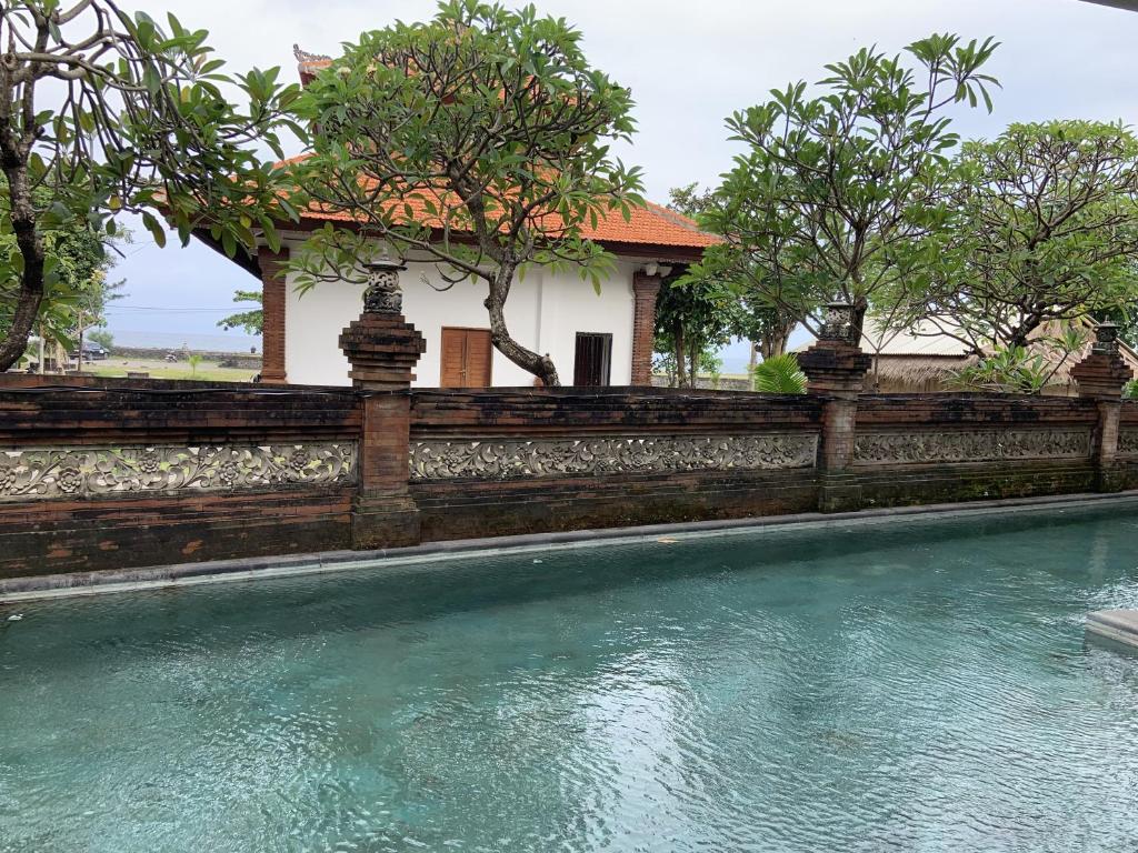 a swimming pool in front of a house at De'Rein Beach House in Sanur