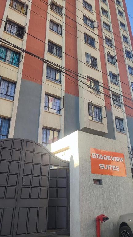 a tall building with a sign in front of it at STADEVIEW MODERN STUDIOs in Gatunga