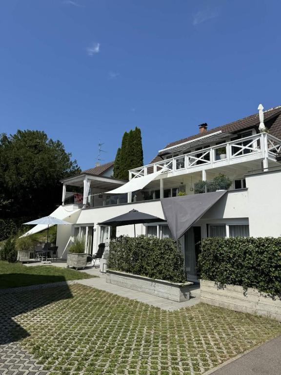 a large white building with umbrellas in front of it at Bodenseeapartments Kunst & Design in Immenstaad am Bodensee