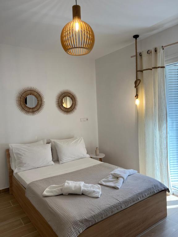 a bedroom with a large bed with two mirrors on the wall at Calm Joy & J - New Bird in Ermoupoli