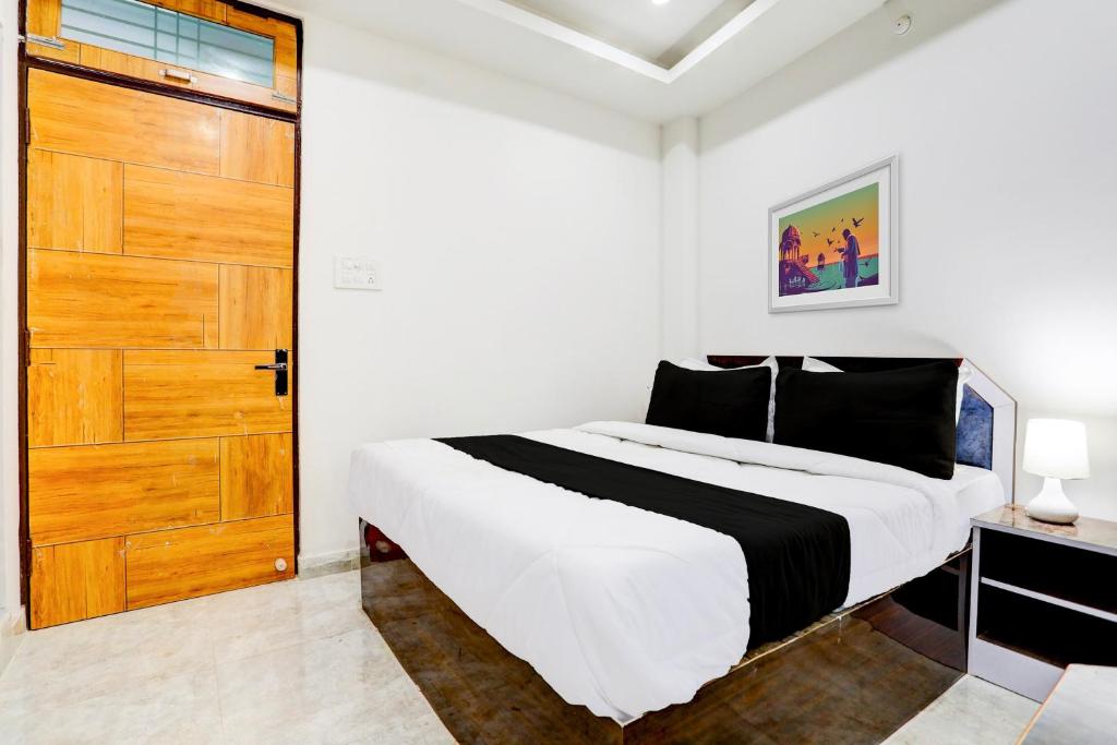 a bedroom with a large bed and a wooden door at Hotel O BGPG House in Varanasi