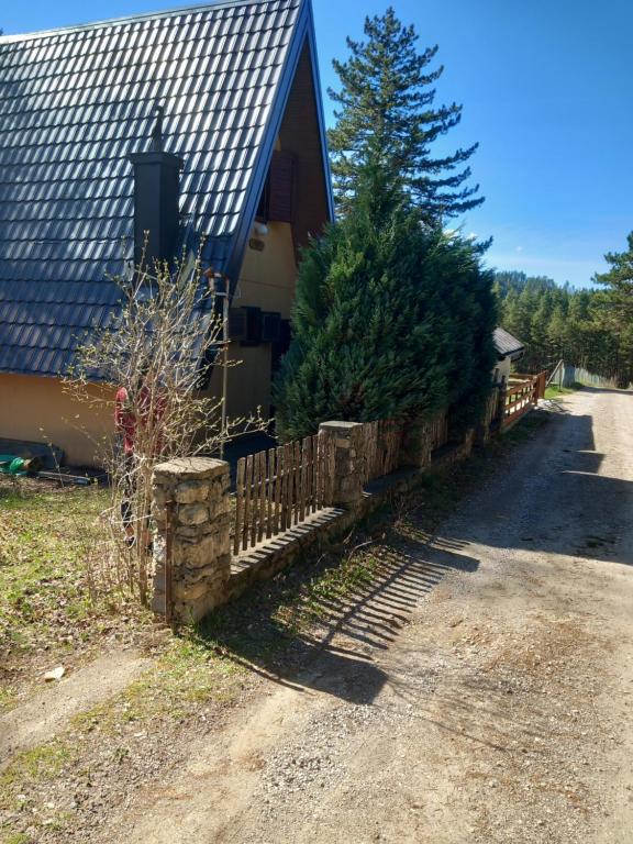 a house with a fence and trees in front of it at jezerski dragulj in Lazići