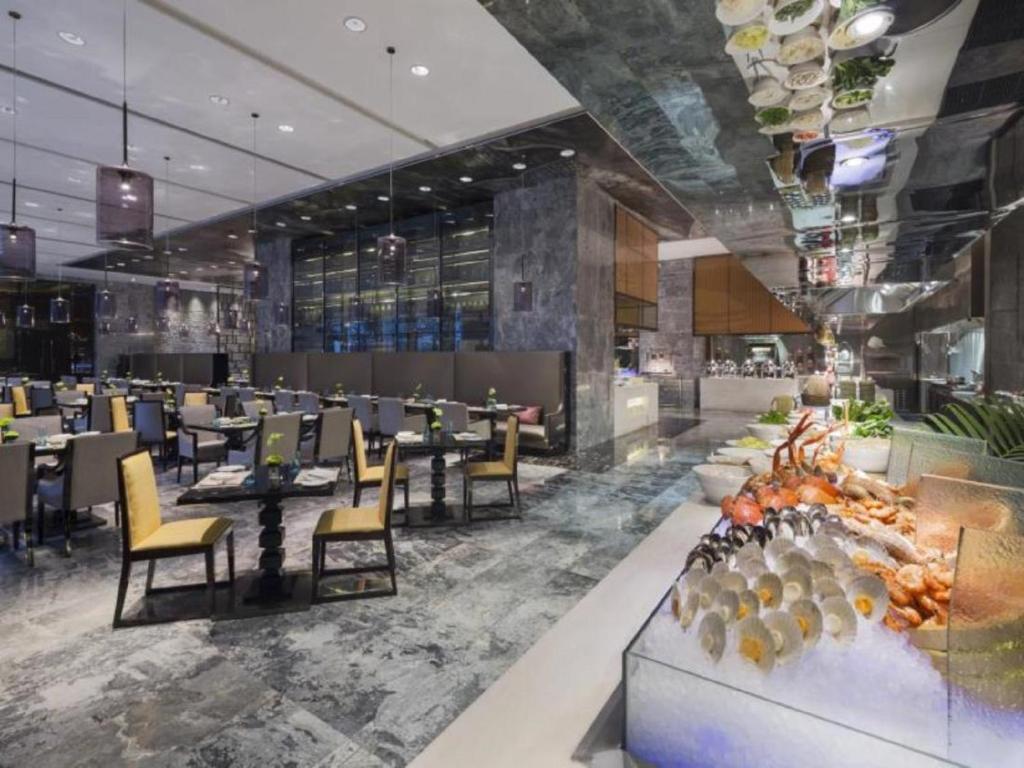 un ristorante con tavoli e sedie nella hall di Wanda Realm Wuhan a Wuhan