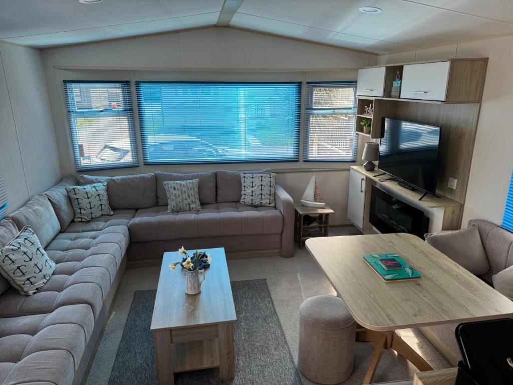a living room with a couch and a table at Captain's Cabin - Brixham - with designated parking in Brixham