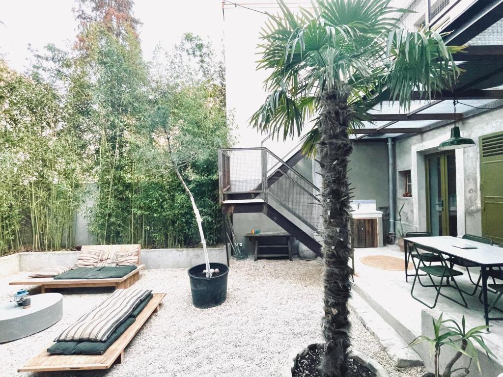 a patio with a palm tree and a table at Respiro in Paris