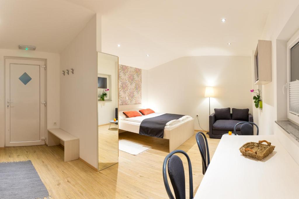 - une chambre avec un lit et une chambre avec une table dans l'établissement Apartments SHISHKA, à Ljubljana